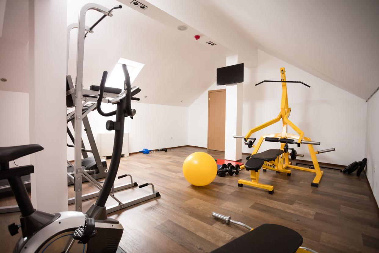 Modern private gym in attic of home equiped with all nececary appliance, exercise machines, mats, weights... Well illuminated from the roof window and with white walls are very nice place for healthy lifestyle