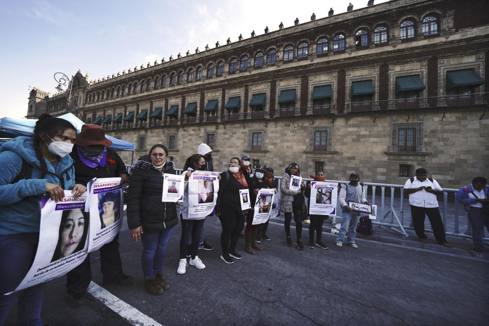 People who have family members who have gone missing gather outside the National Palace to demand answers from the government about the disappeared in Mexico City, Monday, Dec. 13, 2021. (AP Photo/Marco Ugarte)