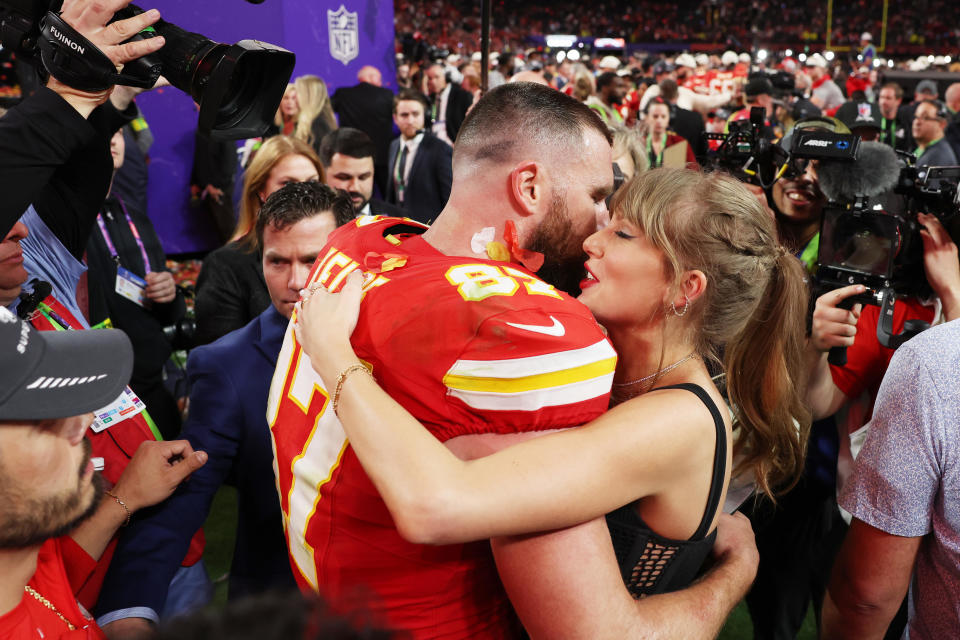 Travis Kelce #87 of the Kansas City Chiefs and Taylor Swift embrace on the field after the Chiefs' victory in Super Bowl LVIII. / Credit: / Getty Images