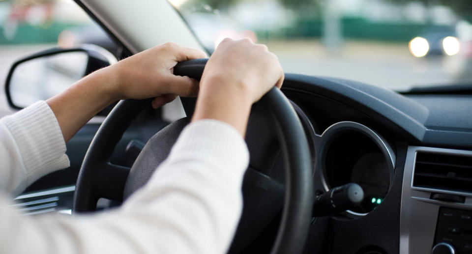 Driver with hands on steering wheel. 