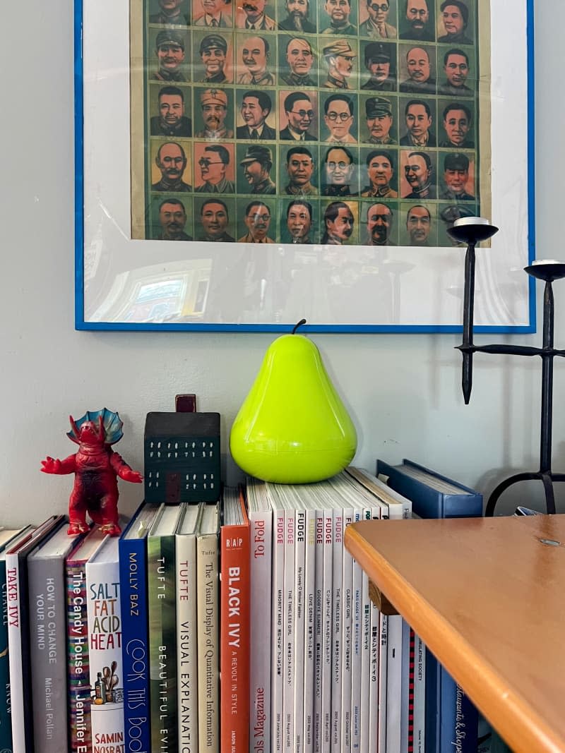 Vintage communist leader poster in a blue frame above a books