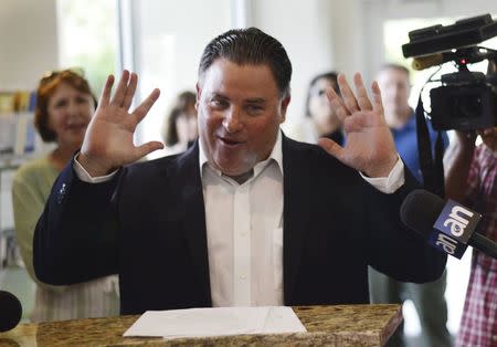 Suspended Miami Lakes Mayor Michael Pizzi talks to reporters in the lobby of Miami Lakes Town Hall in Miami Lakes, Florida August 18, 2014. REUTERS/Zachary Fagenson