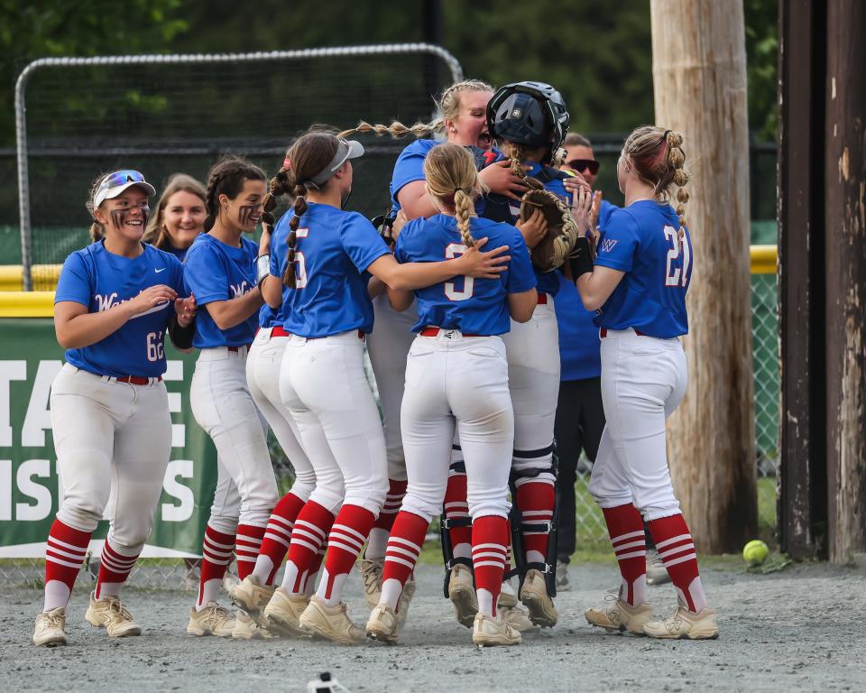 Maddy Eaton, center, and members of the Winnacunnet High School softball team rush catcher Maeva Shapiro after last year's 4-2 win over rival Exeter in a Division I softball semifinal at Plymouth State University.