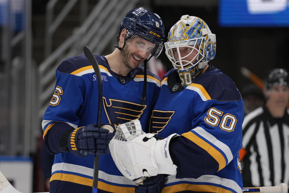 St. Louis Blues goaltender Jordan Binnington (50) and Marco Scandella (6) celebrate a 4-2 victory over the Ottawa Senators in an NHL hockey game Thursday, Dec. 14, 2023, in St. Louis. (AP Photo/Jeff Roberson)