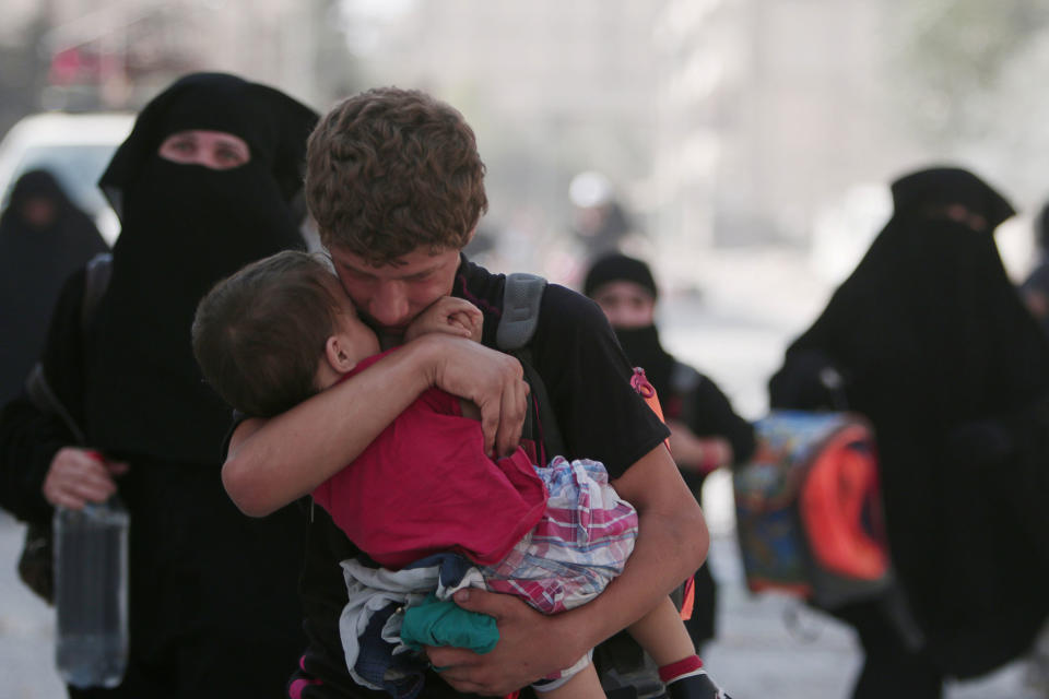 <p>A civilian carries a child as he walks with others after they were evacuated by the Syria Democratic Forces (SDF) fighters from an Islamic State-controlled neighbourhood of Manbij, in Aleppo Governorate, Syria, Aug. 12, 2016. (REUTERS/Rodi Said) </p>