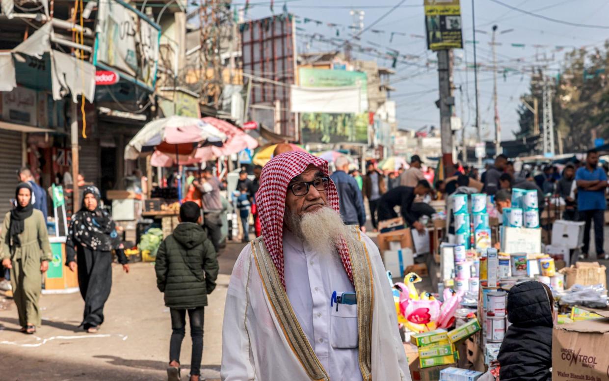 An elderly man walks along a market street in Rafah in the southern Gaza Strip