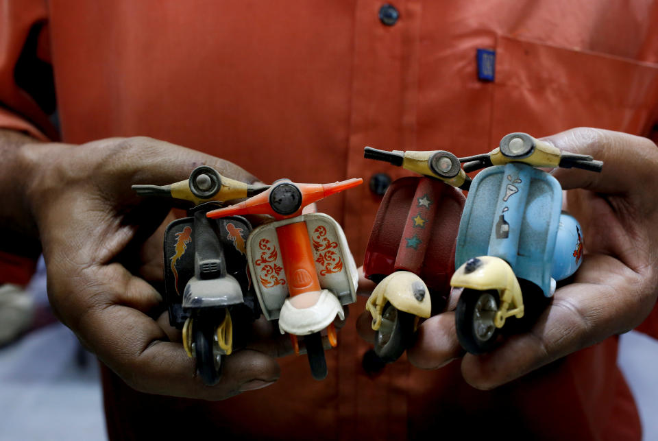 <p>A shopkeeper and Vespa enthusiast holds his collection of mini memorabilia, at his auto parts shop in Karachi, Pakistan Feb. 28, 2018. (Photo: Akhtar Soomro/Reuters) </p>