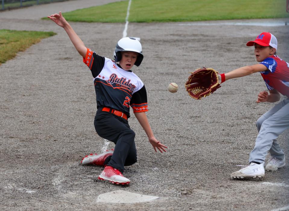 Summerfield's Wyatt Whitting sidles home as Jayson Hatala takes a throw for Monroe Saturday during the opening day of the 63rd annual Monroe County Fair Baseball Tournament.