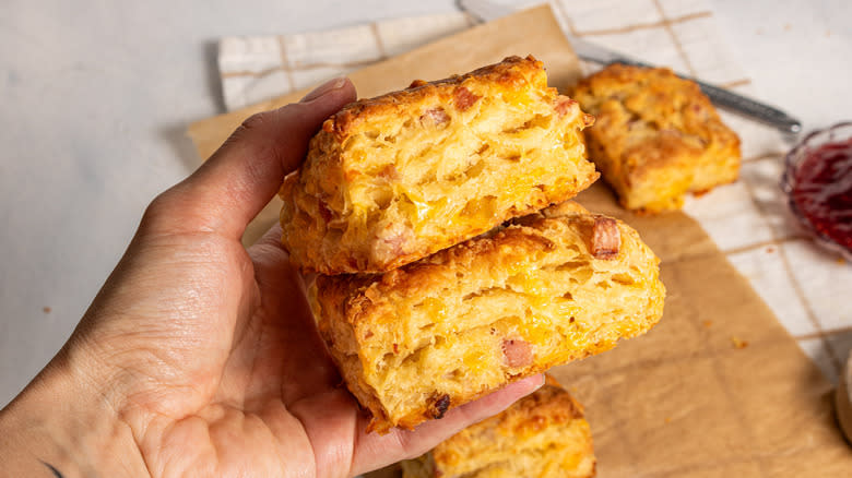 Holding two ham and cheese biscuits