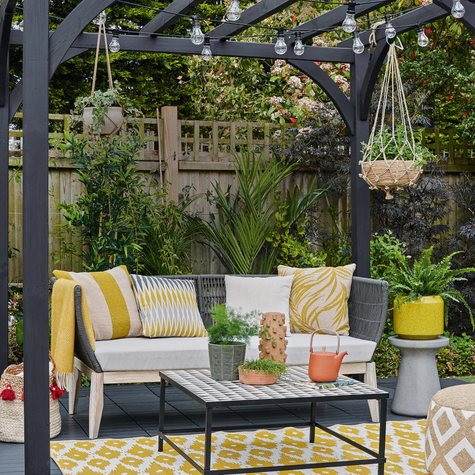 Black decking area covered with pergola