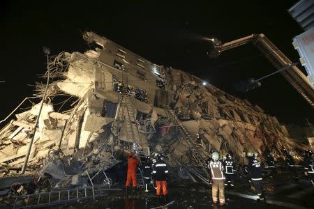 Rescue personnel work at a damaged building after an earthquake in Tainan, southern Taiwan, February 6, 2016. REUTERS/Stringer