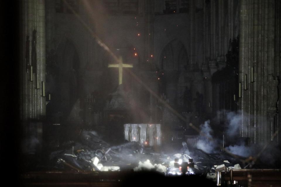 The first photos from inside the Notre Dame cathedral showed extensive damage a massive fire caused after engulfing the historic edifice. The altar at the helm of the beloved cathedral appeared all but entirely burned down by the blaze, as smoke still appeared to be rising from the ashes in a photo seemingly taken shortly after firefighters began containing the flames. A golden cross was seemingly left intact, hanging above the destruction that once was the ornate focus for millions of visitors who marvelled at the longstanding structure and its global impact on culture and history.The blaze collapsed the cathedral’s spire and spread to one of its landmark rectangular towers, but Paris fire chief Jean-Claude Gallet said the church’s structure had been saved after firefighters managed to stop the fire spreading to the northern belfry. The 12th century cathedral is home to incalculable works of art and is one of the world’s most famous tourist attractions, immortalised by Victor Hugo’s 1831 novel The Hunchback of Notre Dame.The exact cause of the blaze was not known, but French media quoted the Paris fire brigade as saying the fire is “potentially linked” to a major renovation project on the church’s spire and its 250 tonnes of lead. The Paris prosecutors’ office ruled out arson and possible terror-related motives, and said it was treating it as an accident.> Dans la nef, encombrée par les restes de la flèche en miettes, l’autel est resté intact, avec sa croixNotreDame pic.twitter.com/yify3ERdN0> > — Raphaelle Bacqué (@RaphaelleBacque) > > April 15, 2019Flames shot out of the roof behind the nave of the cathedral, among the most visited landmarks in the world. Hundreds of people lined up bridges around the island that houses the church, watching in shock as acrid smoke rose in plumes. Speaking alongside junior Interior minister Laurent Nunez late Monday, Mr Gallet said “two thirds of the roofing has been ravaged”.Late Monday, signs pointed to the fire nearing an end as lights could be seen through the windows moving around the front of the cathedral, apparently investigators inspecting the scene.The fire came less than a week before Easter amid Holy Week commemorations. As the cathedral burned, Parisians gathered to pray and sing hymns outside the church of Saint Julien Les Pauvres across the river from Notre Dame while the flames lit the sky behind them.The Associated Press contributed to this report