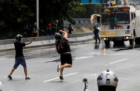 A demonstrator throws a petrol bomb while clashing with riot security forces during a rally against Venezuela's President Nicolas Maduro in Caracas, Venezuela, May 31, 2017. REUTERS/Carlos Garcia Rawlins