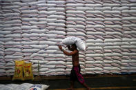 FILE PHOTO: A worker carries on his head a sack of rice inside a government rice warehouse National Food Authority in Quezon city, Metro Manila in Philippines, August 9, 2018. REUTERS/Erik De Castro/File Photo