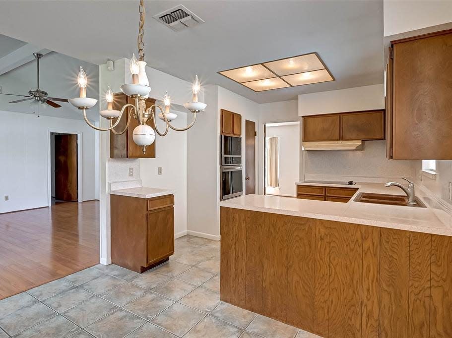 an outdated kitchen with wood cabinetry in a house for sale in houston