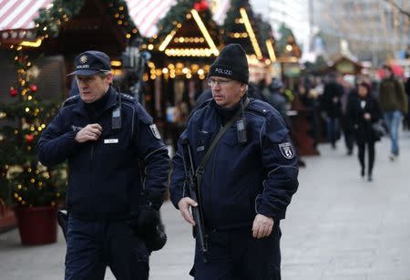 Police patrol among people at the re-opened Christmas market at Breitscheid square. REUTERS/Hannibal Hanschke