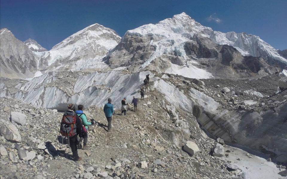 Trekkers pass through a glacier at the Mount Everest base camp, Nepal - Credit: Tashi Sherpa