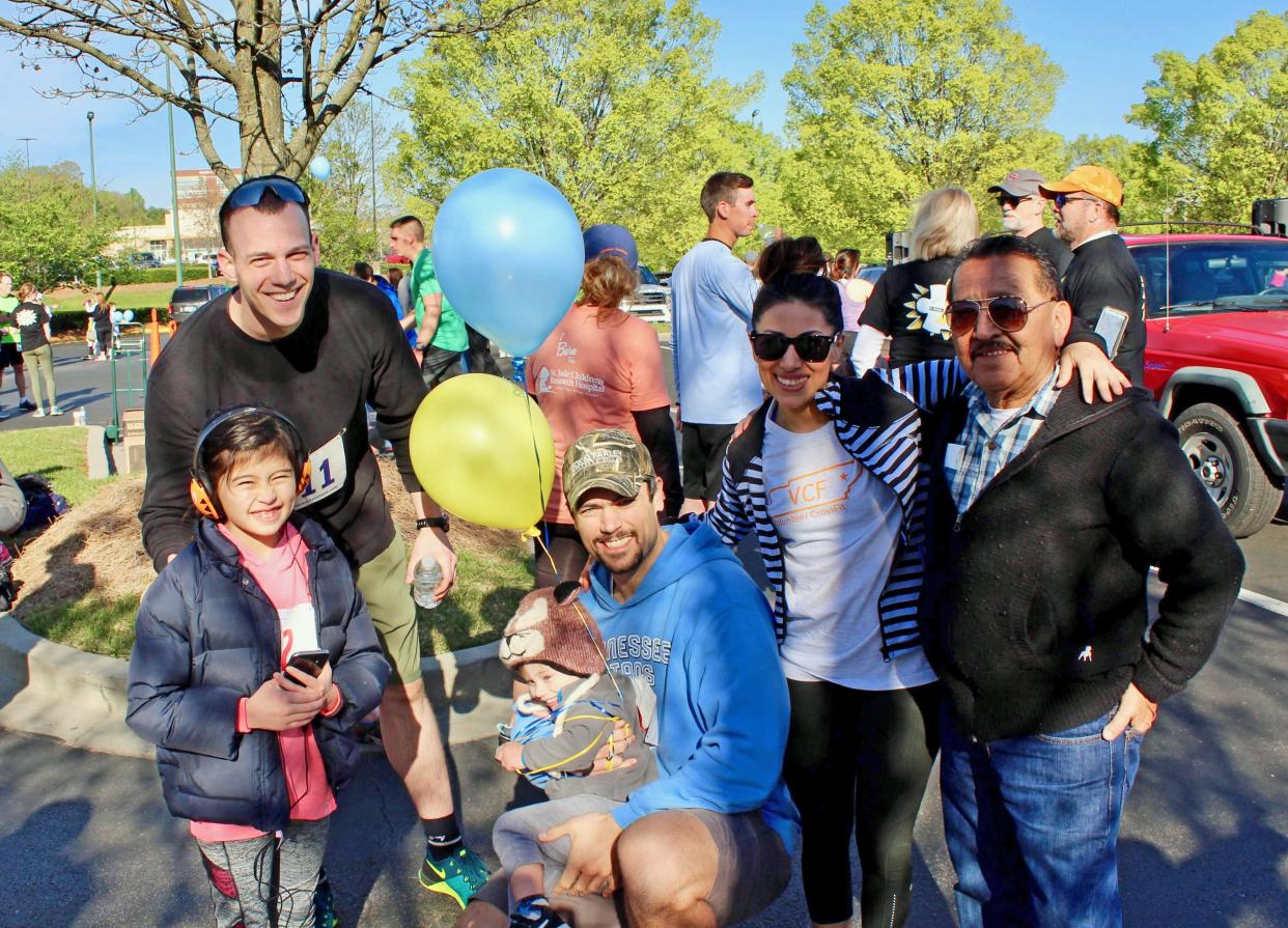 Tim Younkin, left, joins the Beehan family of Oak Ridge, from left, Soly, Michael holding Gus, Lissie, and Lissie’s father Roberto Meza at an earlier race supporting Autism Breakthrough of Knoxville. The group ran and walked in honor of Gus and the Beehans' cousin Luke.