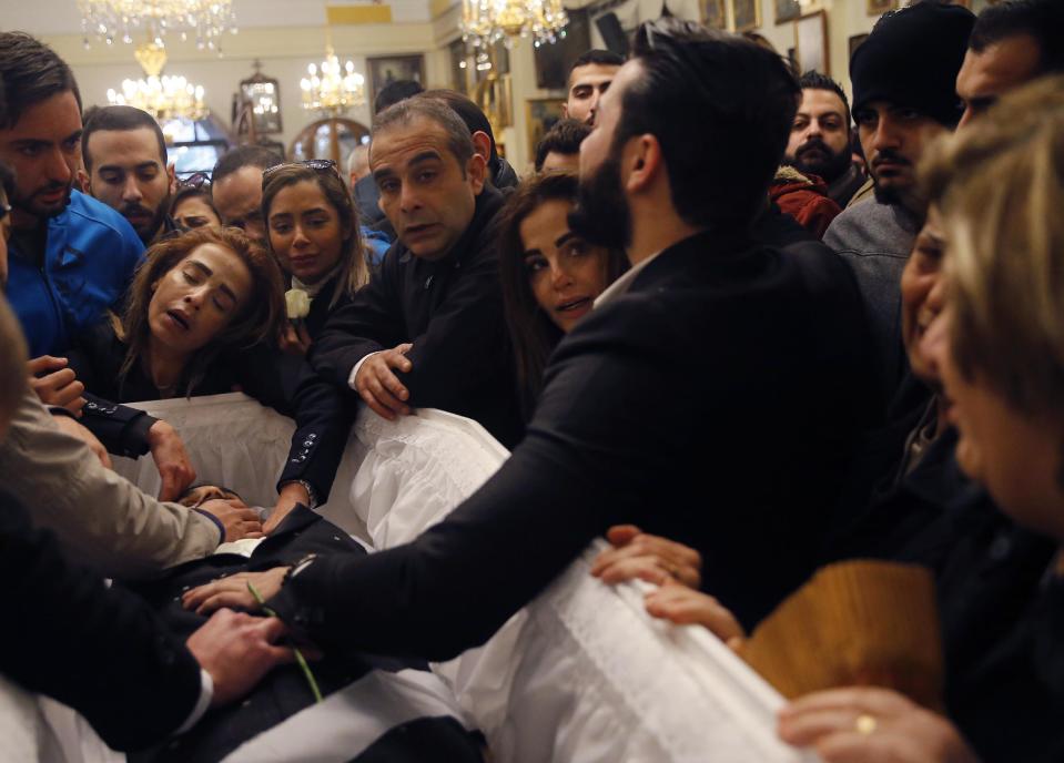 Relatives of a Lebanese man who was killed in the New Year's Eve Istanbul nightclub attack, mourns over his body during the funeral procession, at a church, in Beirut, Lebanon, Tuesday, Jan. 3, 2017. The gunman killed 39 people, most of them foreigners, including three Lebanese citizens, at the Istanbul nightclub. The Islamic State group claimed the attack on Monday, saying a "soldier of the caliphate" had carried out the mass shooting in response to Turkish military operations against IS in northern Syria. (AP Photo/Hussein Malla)