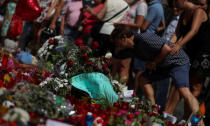 A man places flowers at an impromptu memorial where a van crashed into pedestrians at Las Ramblas in Barcelona, Spain August 21, 2017. REUTERS/Sergio Perez