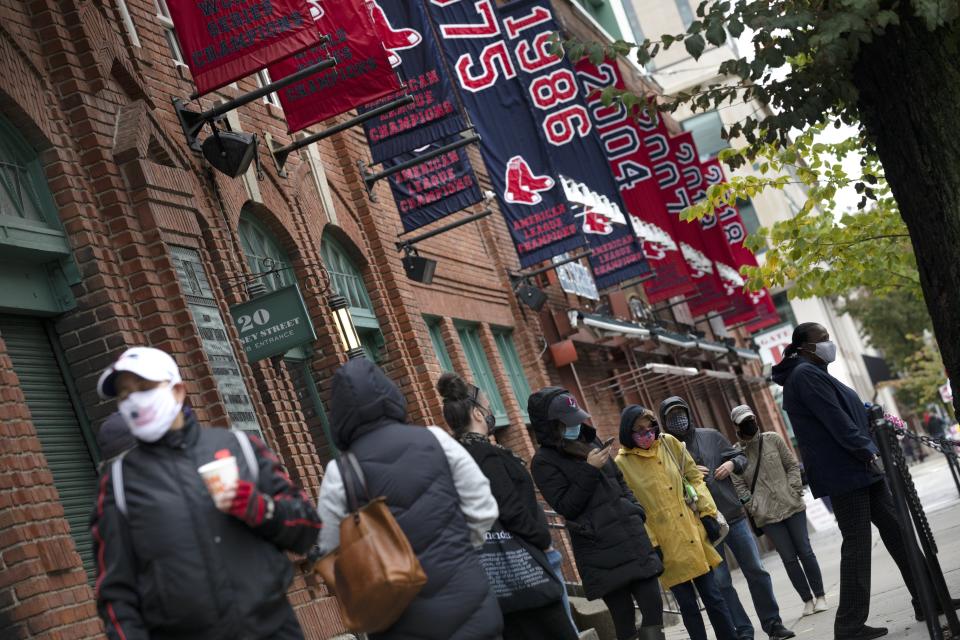 People wait in line for early voting to open at Fenway Park, Saturday, Oct. 17, 2020, in Boston. (AP Photo/Michael Dwyer)