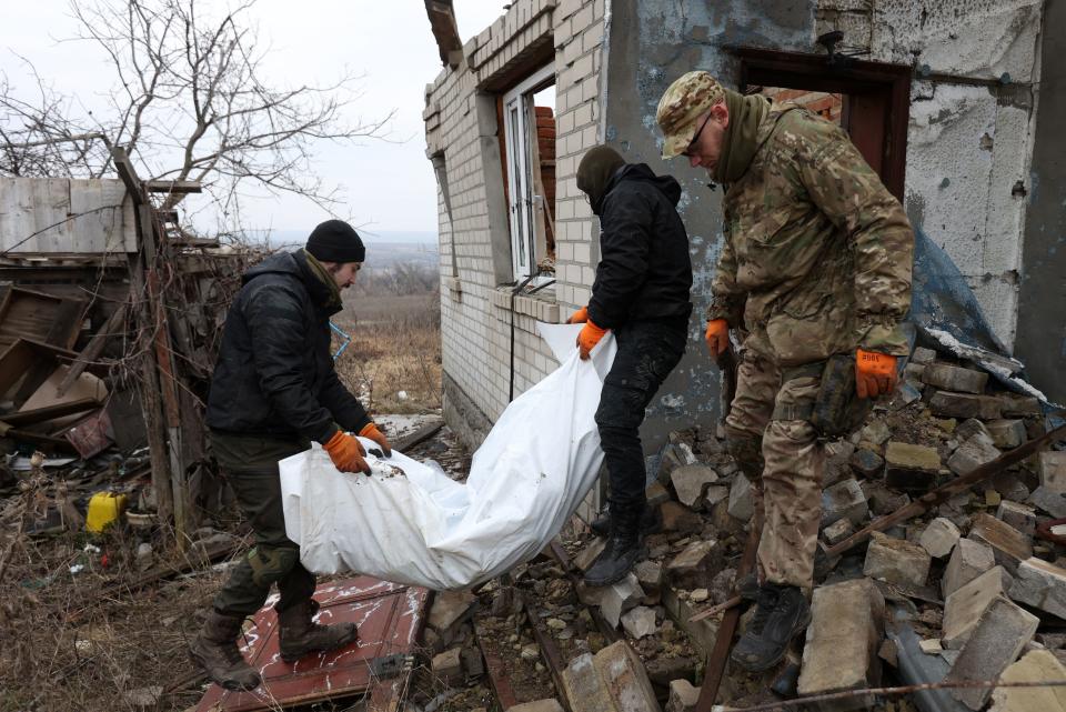 Voluntarios ucranianos transportan el cuerpo sin vida de un soldado de Putin.(Photo by ANATOLII STEPANOV/AFP via Getty Images)