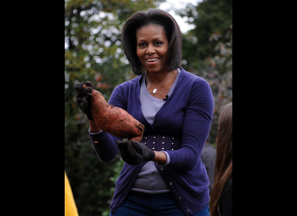 US First lady Michelle Obama holds a sweet patato during a fall harvest of the White House vegetable garden on October 29, 2009 in Washington, DC. The First Lady welcomedstudents from Bancroft Elementary and Kimball Elementary to the South Lawn of the White House for the Fall Harvest of the White House Kitchen Garden.   AFP PHOTO / Tim Sloan (Photo credit should read TIM SLOAN/AFP/Getty Images)