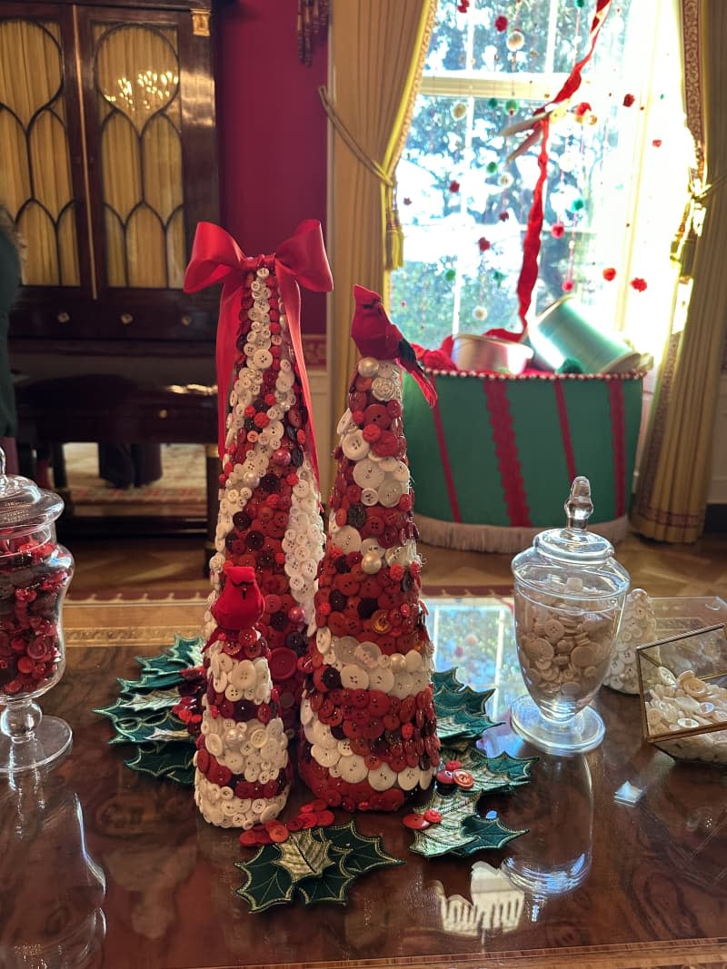 white and red small garland christmas trees on table