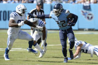 Tennessee Titans running back Derrick Henry (22) gets past Indianapolis Colts defensive tackle Al-Quadin Muhammad (97) and safety Andrew Sendejo (42) in the second half of an NFL football game Sunday, Sept. 26, 2021, in Nashville, Tenn. (AP Photo/Mark Zaleski)