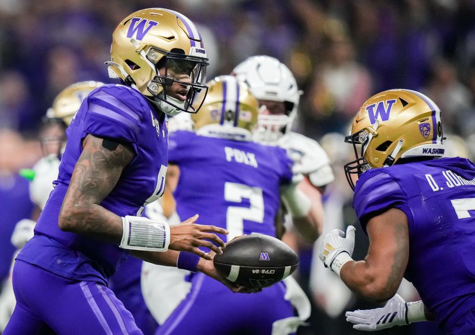 Washington Huskies quarterback Michael Penix Jr. (9) hands the ball off to running back Dillon Johnson (7) during the Sugar Bowl College Football Playoff semi-finals at the Ceasars Superdome in New Orleans, Louisiana, Jan. 1, 2024. The Huskies won the game over the Texas Longhorns 37-31. Credit: Sara Diggins/American-Statesman-USA TODAY NETWORK