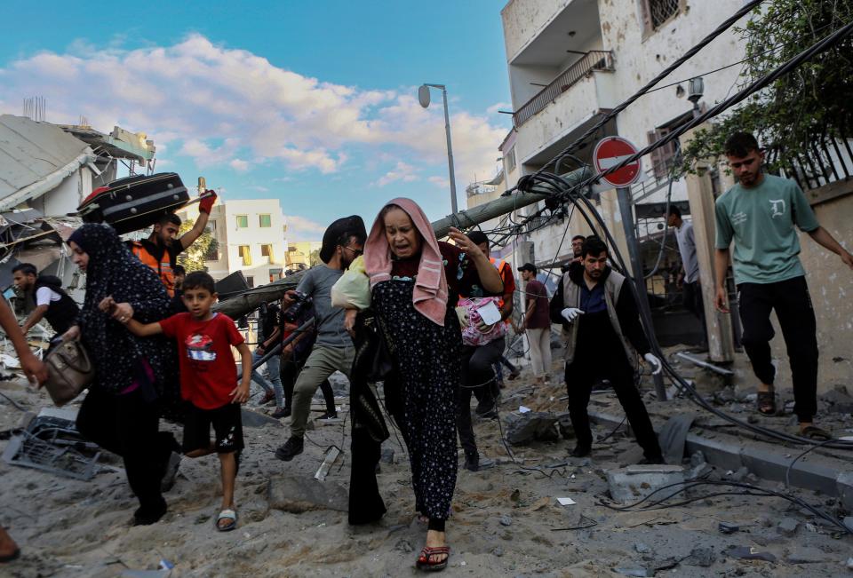 Palestinian families rush out of their homes after Israeli airstrikes targeting their neighbourhood in Gaza City (Copyright 2023 The Associated Press. All rights reserved.)