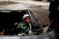 Boys play in an abandoned car in the yard of The al-Shawkani Foundation for Orphans Care in Sanaa, Yemen, February 18, 2017. REUTERS/Khaled Abdullah