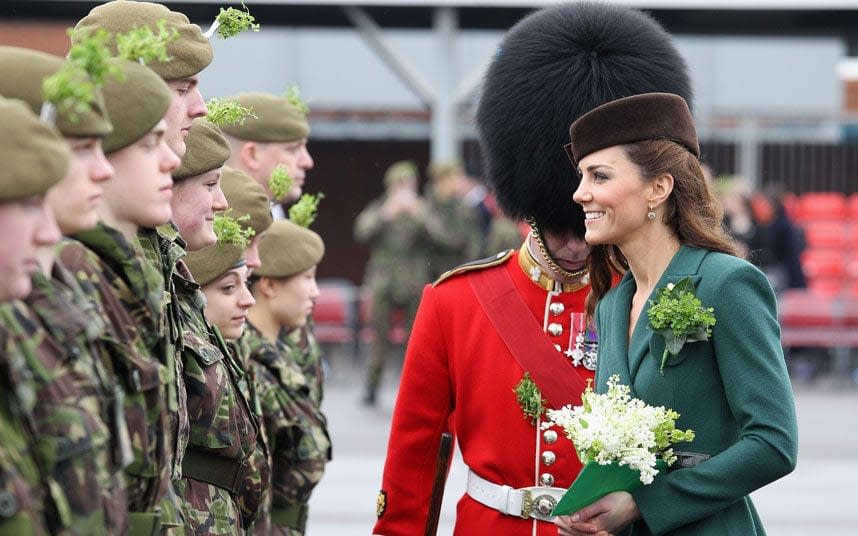 The Duchess of Cambridge presents shamrocks to Irish Guards during a St Patrick's Day parade at Aldershot Barracks - Credit: Getty