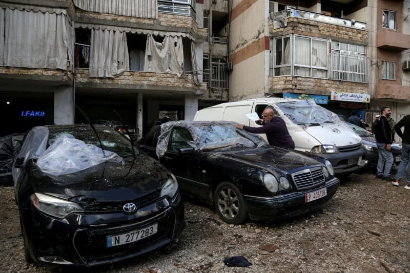 A Lebanese man checks his destroyed car following an Israeli attack on Hamas' office on 02 January, killing Hamas leader Saleh al-Arouri and six others in Beirut southern suburb. Marwan Naamnai/dpa
