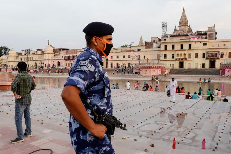 An armed police officer stands guard on the bank of Sarayu river ahead of the foundation-laying ceremony for a Hindu temple in Ayodhya