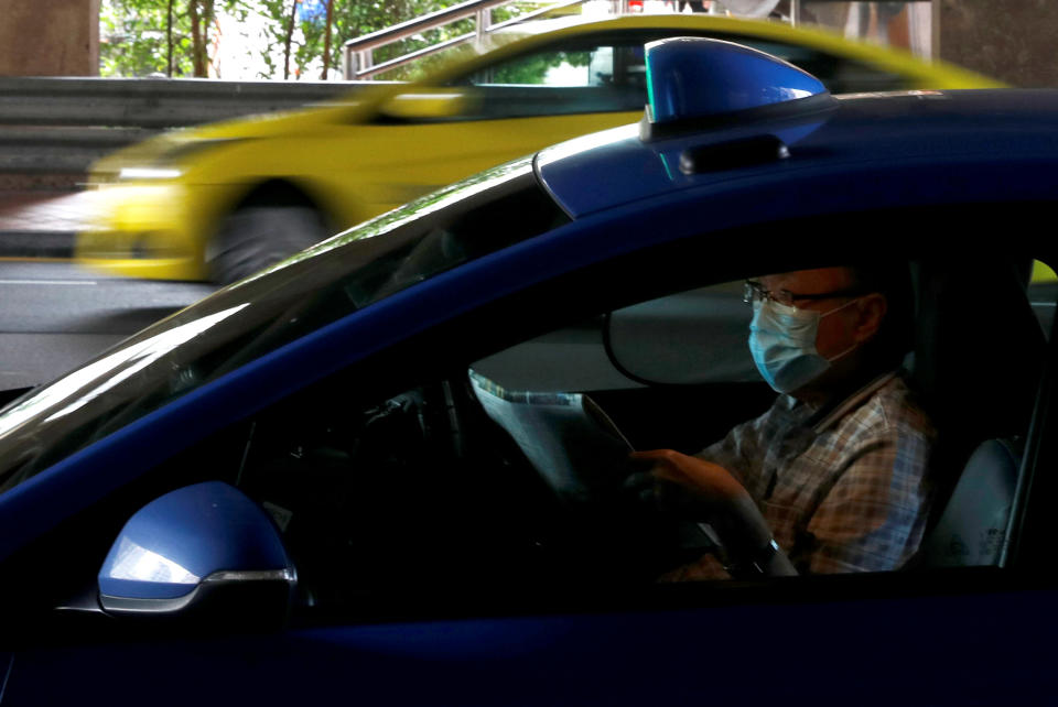 LTA cited the example of a parent being allowed to travel with his or her two children in the same taxi or PHC during the Phase 2 (Heightened Alert) period. (PHOTO: Reuters)