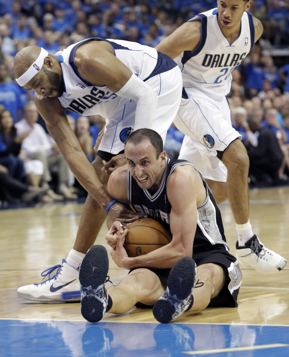 San Antonio Spurs guard Manu Ginobili, bottom, fights for the ball with Dallas Mavericks guard Vince Carter, left, as Devin Harris (20) looks on during the second half in Game 3 in the first round of the NBA basketball playoffs in Dallas, Saturday, April 26, 2014. The Mavericks won 109-108. (AP Photo/LM Otero)