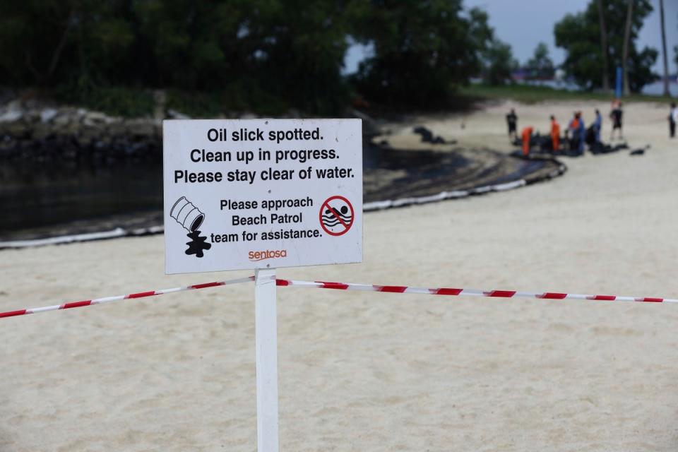 A signboard warning of oil spill is seen along Sentosa's Tanjong Beach area in Singapore (AP)