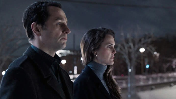 Matthew Rhys and Keri Russell stand next to each other in The Americans.