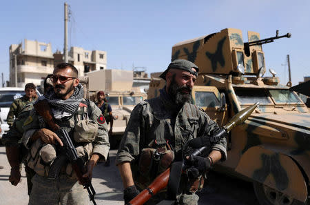 Fighters of Syrian Democratic Forces carry weapons at the frontline in Raqqa, Syria October 16, 2017. REUTERS/Rodi Said