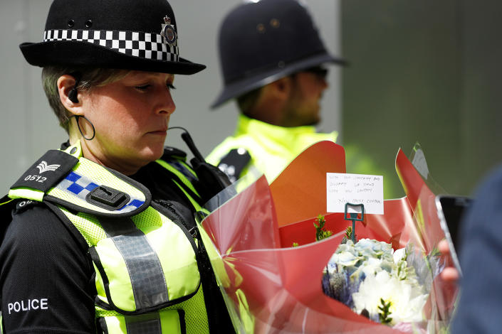 <p>A police officer carries a bunch of flowers with a note near Borough Market in London, June 4, 2017. (Photo: Peter Nicholls/Reuters) </p>