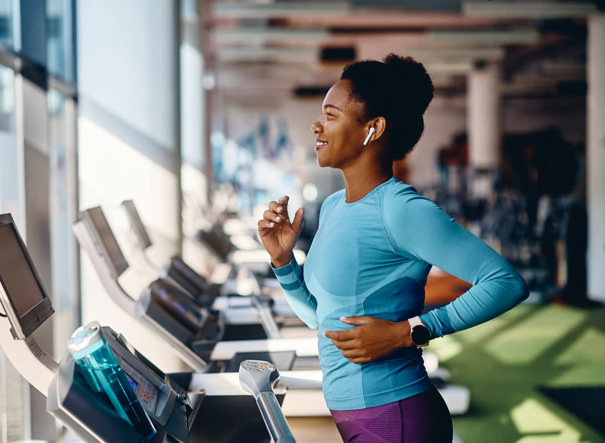 fit woman running on treadmill, concept of treadmill or elliptical which is more effective