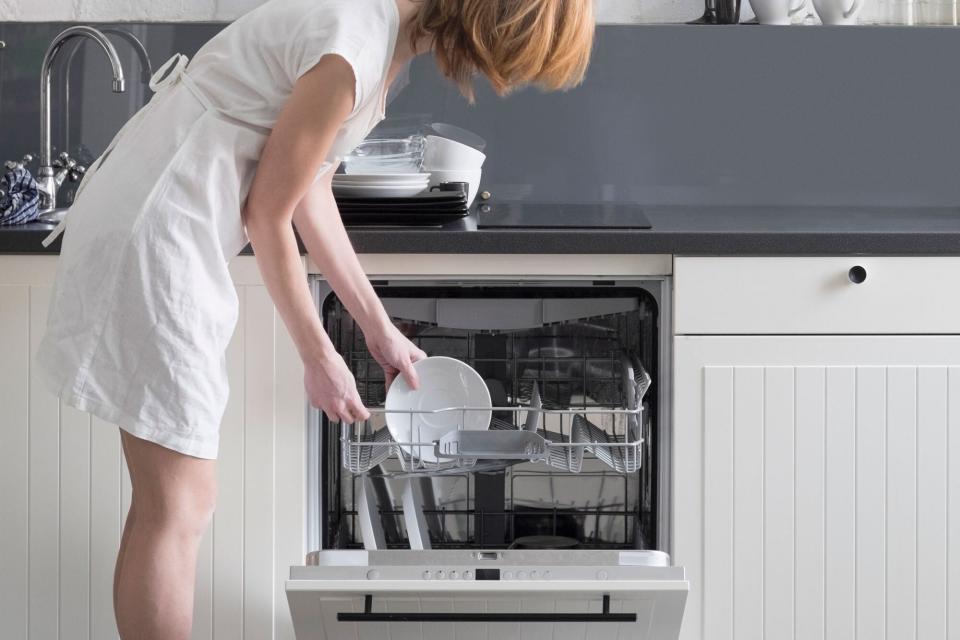 A woman loading a dishwasher