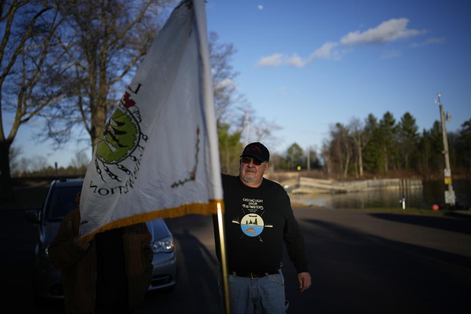 John Johnson, tribal president of the Lac du Flambeau Band of Lake Superior Chippewa Indians, helps set up a tribal flag during a youth spearfishing event Saturday, April 20, 2024, in Lac Du Flambeau, Wis. (AP Photo/John Locher)