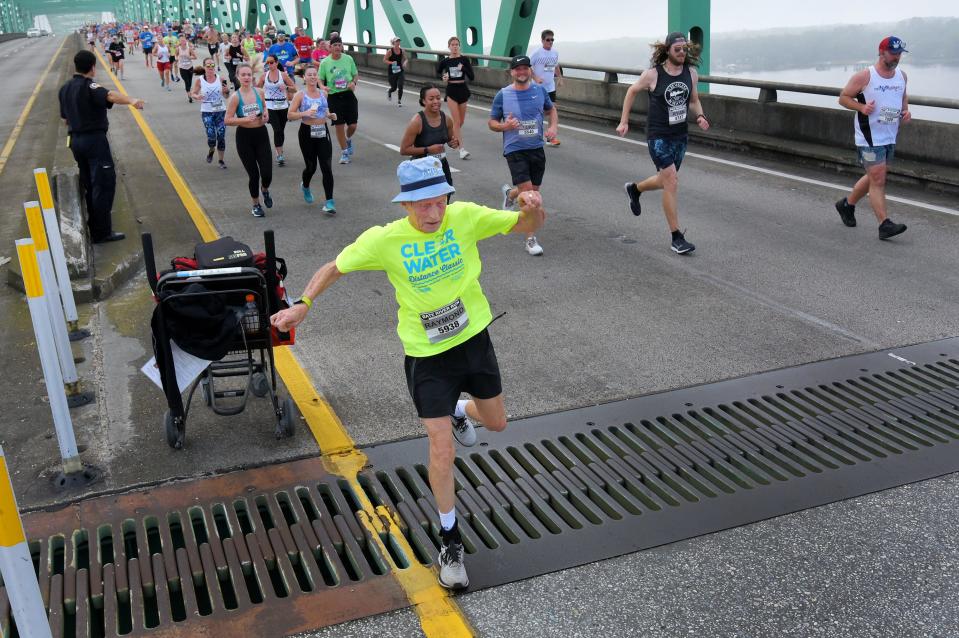 Runner Raymond Bell, 74, hurdles the expansion joint on the down side of the Hart Bridge as he runs in the 2022 Gate River Run.