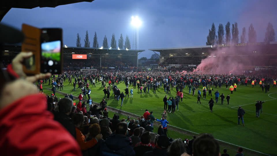 Wrexham's fans celebrate on the pitch after the club won the title.  - Oli Scarff/AFP/Getty Images