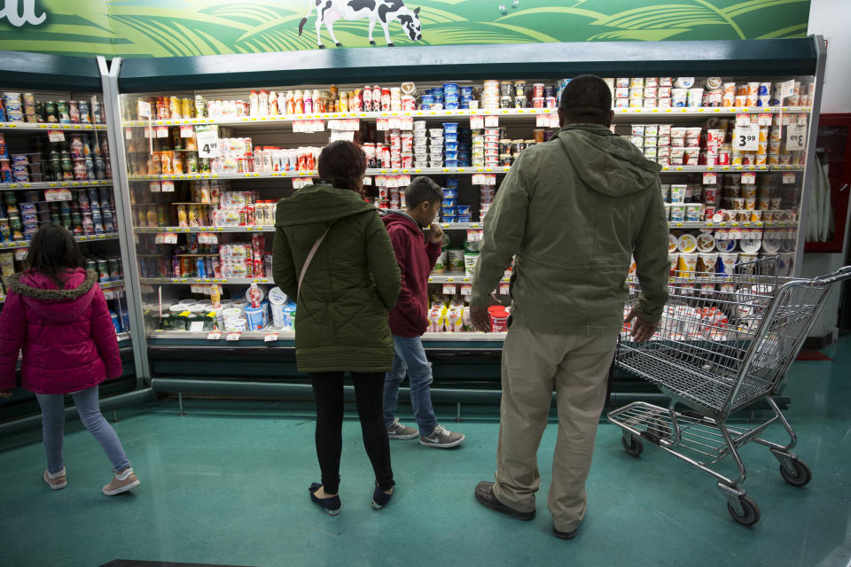 Lorena and her children shop at the grocery store in Juarez with Alex Varela on Nov. 28, to buy food for the temporary home they are staying at until their numbers are up on the waiting list. (Photo: Adria Malcolm for Yahoo News)