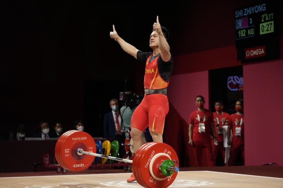 Shi Zhiyong of China celebrates after winning the gold medal in the men's 73kg weightlifting event, at the 2020 Summer Olympics, Wednesday, July 28, 2021, in Tokyo, Japan. (AP Photo/Luca Bruno)