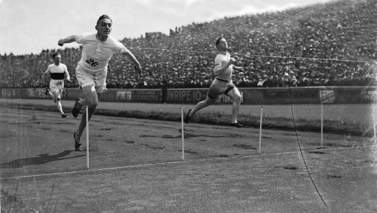 British sprinter Harold Abrahams (left) crosses the finish line to win the 100 yards race at the AAA Championships. (PHOTO: Central Press/Getty Images)
