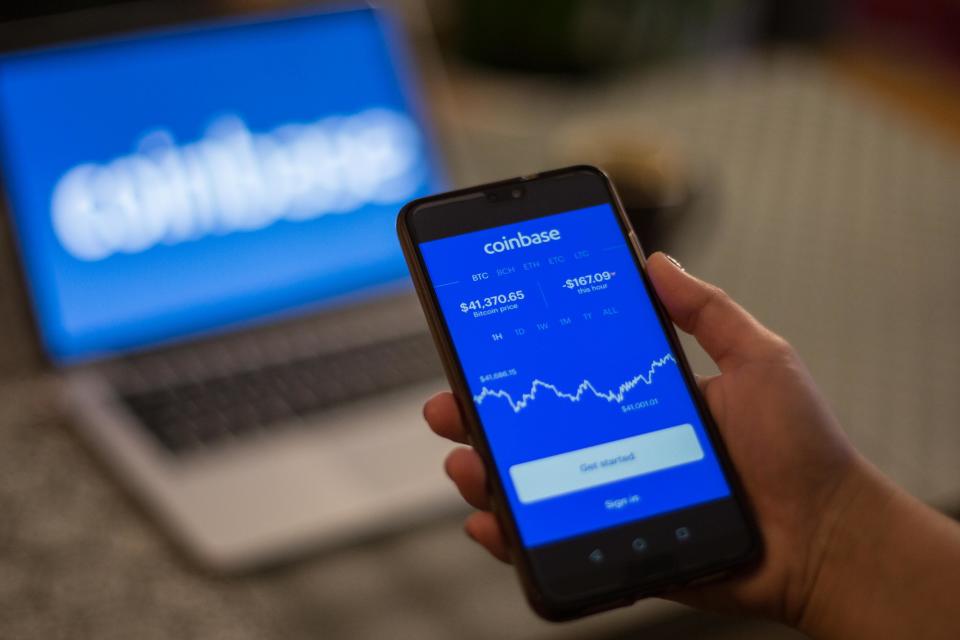 SPAIN - 2021/01/08: In this photo illustration a Coinbase App and logo is seen displayed on a smartphone and a laptop in the background. (Photo Illustration by Thiago Prudêncio/SOPA Images/LightRocket via Getty Images)